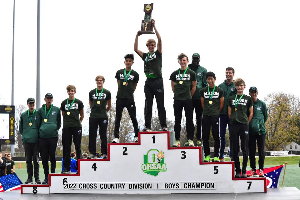 The Mason Comets raise the championship trophy in the Division I boys race at the OHSAA state cross-country championships, Nov. 5, 2022.