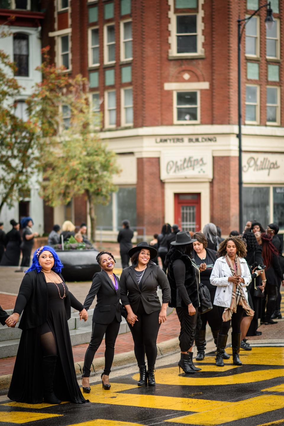 Black women encircle the Market House during the 100 Professional Black Women in Black Photo Shoot in downtown Fayetteville on Saturday, Jan. 6, 2024.