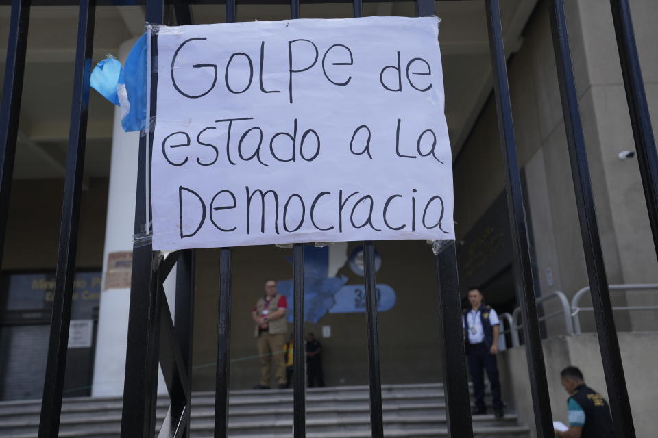 A sign that reads in Spanish "Coup d'état against democracy" hangs from the gate of the Attorney General's office building during a protest in Guatemala City, Thursday, July 13, 2023. The Attorney General's Office announced on July 12 that a judge had suspended the legal status of the Seed Movement political party for alleged violations when it gathered the necessary signatures to form. The party's presidential candidate had been set to compete in a runoff election on Aug. 20. (AP Photo/Moises Castillo)
