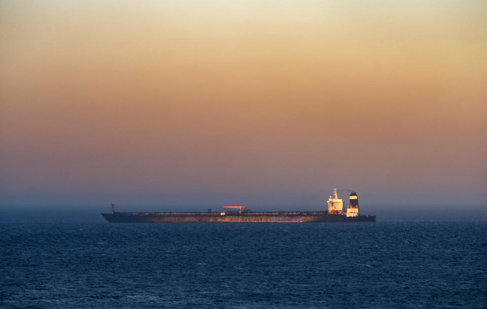 A supertanker hosting an Iranian flag is seen on the water in the British territory of Gibraltar, Sunday, Aug. 18, 2019. Authorities in Gibraltar on Sunday rejected the United States' latest request not to release a seized Iranian supertanker, clearing the way for the vessel to set sail after being detained last month for allegedly attempting to breach European Union sanctions on Syria. (AP Photo/Marcos Moreno)