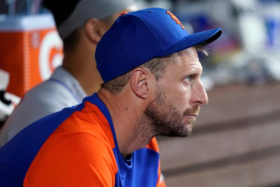 New York Mets pitcher Max Scherzer watches from the dugout during a baseball game against the Miami Marlins, Saturday, June 25, 2022, in Miami. The three-time Cy Young Award winner has been sidelined since May 19 because of an oblique strain. (AP Photo/Lynne Sladky)