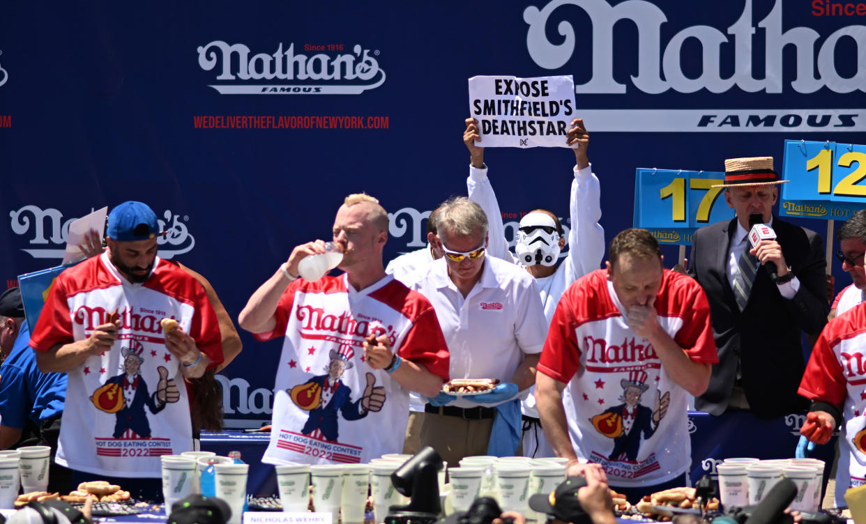A protestor interrupts defending champion Joey Chestnut competing in the 2022 Nathans Famous Fourth of July International Hot Dog Eating Contest at Coney Island on July 04, 2022. (Alexi Rosenfeld / Getty Images)