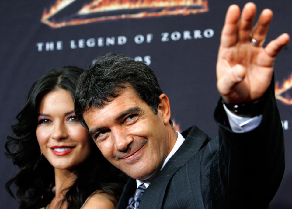 Actor Antonio Banderas waves as co-star actress Catherine Zeta-Jones looks on at the premiere of "The Legend of Zorro" at the Orpheum theatre in Los Angeles October 16, 2005. The movie tells the story of Don Alejandro de la Vega, Zorro (Banderas), and his wife Elena (Zeta-Jones) as they deal with a threat to California becoming the 31st state of the Union. The movie opens in the U.S. on October 28. REUTERS/Mario Anzuoni