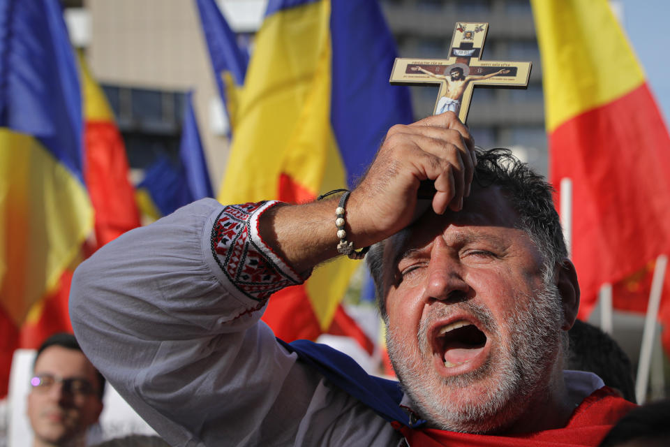 A man shouts slogans against the use of face masks as a means of protection against the COVID-19 infection during a protest in Bucharest, Romania, Saturday, Sept. 19, 2020. Several hundred Romanians, including many families with young children, held a protest in the country's capital against measures meant to curb the spread of the coronavirus, especially social distancing and the mandatory use of masks in schools. (AP Photo/Vadim Ghirda)