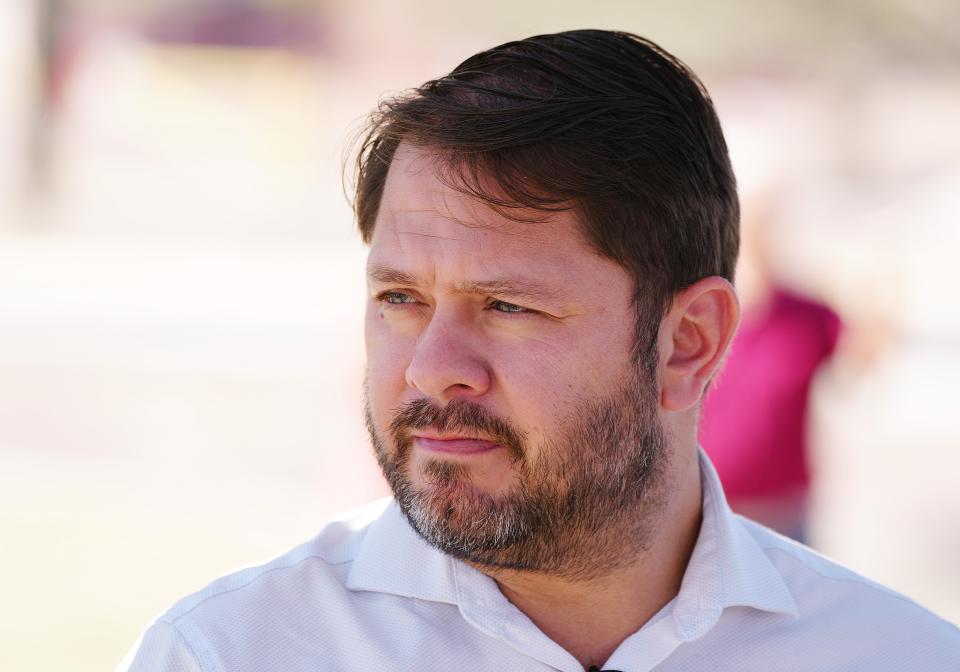 Rep. Ruben Gallego looks over trees during a tour of recently planted trees along Baseline Road on April 20, 2022, in Phoenix.