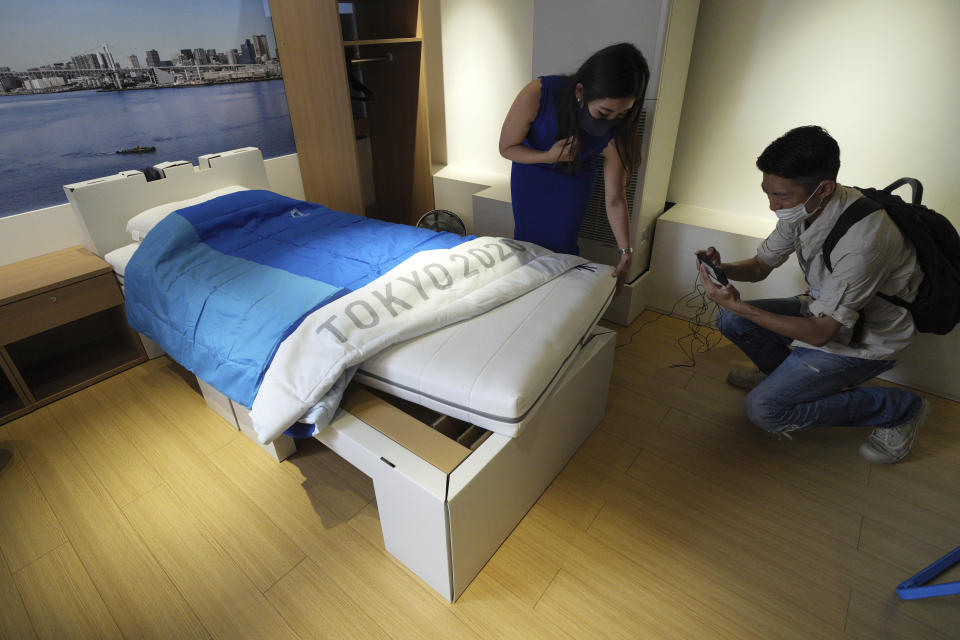 Journalists look at cardboard beds for the Tokyo 2020 Olympic and Paralympic at the Village Plaza near Tokyo 2020 Olympic and Paralympic Village Sunday, June 20, 2021, in Tokyo. (AP Photo/Eugene Hoshiko)