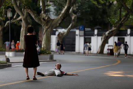 A man poses for photos on an empty road near the West Lake, as police closed off many roads before G20 Summit in Hangzhou, Zhejiang Province, China August 31, 2016. REUTERS/Aly Song