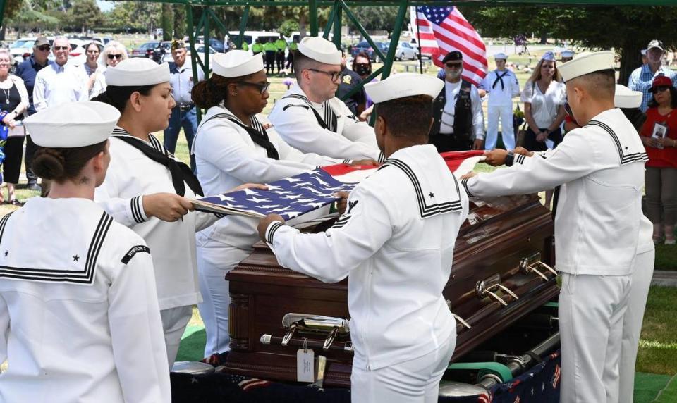 A naval honor guard detail folds the American flag that had draped the casket of Seaman 2nd Class Denver True “D.T.” Kyser, as he is laid to rest in a ceremony at Fresno Memorial Gardens Saturday afternoon, May 21, 2022 in Fresno. Kyser, 18 at the time, was assigned to and serving on the battleship USS Oklahoma when it was attacked by Japanese aircraft as it was moored at Ford Island, Pearl Harbor on Dec. 7, 1941.