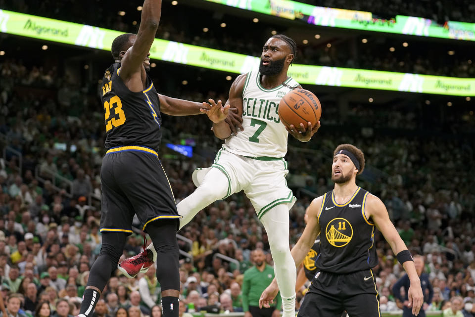 Boston Celtics guard Jaylen Brown (7) goes up for a shot against Golden State Warriors forward Draymond Green (23) and guard Klay Thompson (11) during the second quarter of Game 4 of basketball's NBA Finals, Friday, June 10, 2022, in Boston. (AP Photo/Steven Senne)