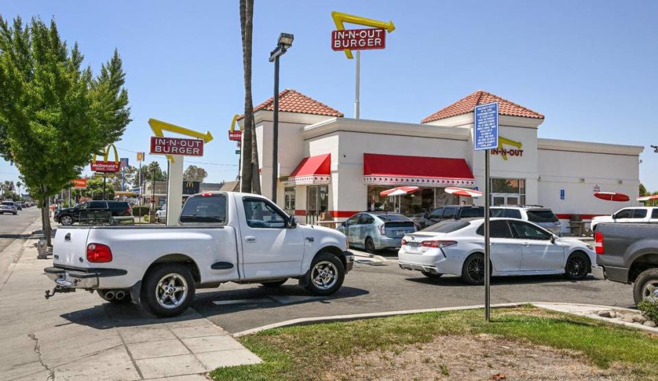 Cars are backed up into West Shaw Avenue while waiting to get to the drive-thru window at In-N-Out Burger near Highway 99 in Fresno on Monday, Aug. 7, 2023. Traffic issues have occurred in the area for years as vehicles wait in the drive-thru line. But the business just received approvals to increase the length of the drive-thru and add 37 parking spaces.