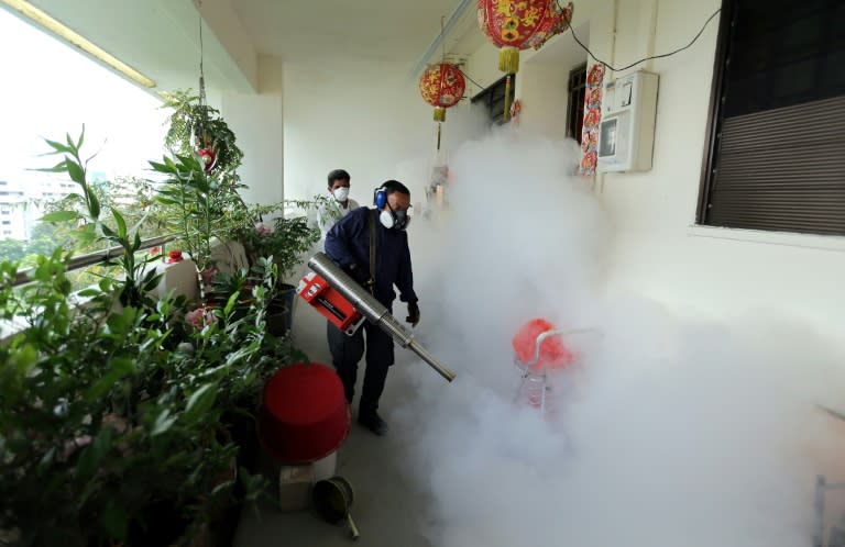 Workers are seen fogging a housing estate in Singapore on August 28, 2016 after authorities reported more than 40 locally transmitted cases of the Zika virus