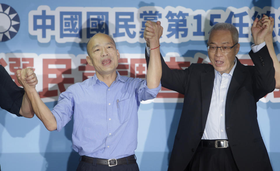 Kaohsiung city mayor Han Kuo-yu, left, celebrates with Wu Den-yih, chairman of the opposition National Party (KMT), during a media event after winning the candidacy of the opposition of the Nationalist Party (KMT) for the upcoming presidential elections at the party headquarters, Monday, July 15, 2019, in Taipei, Taiwan. (AP Photo/Chiang Ying-ying)