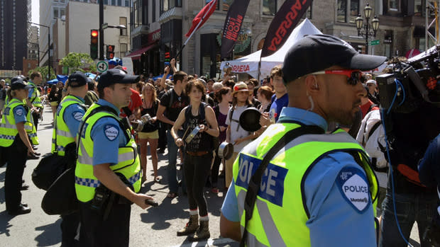 Police watch as protesters approach the site of the grand prix's downtown festivities Saturday afternoon. 