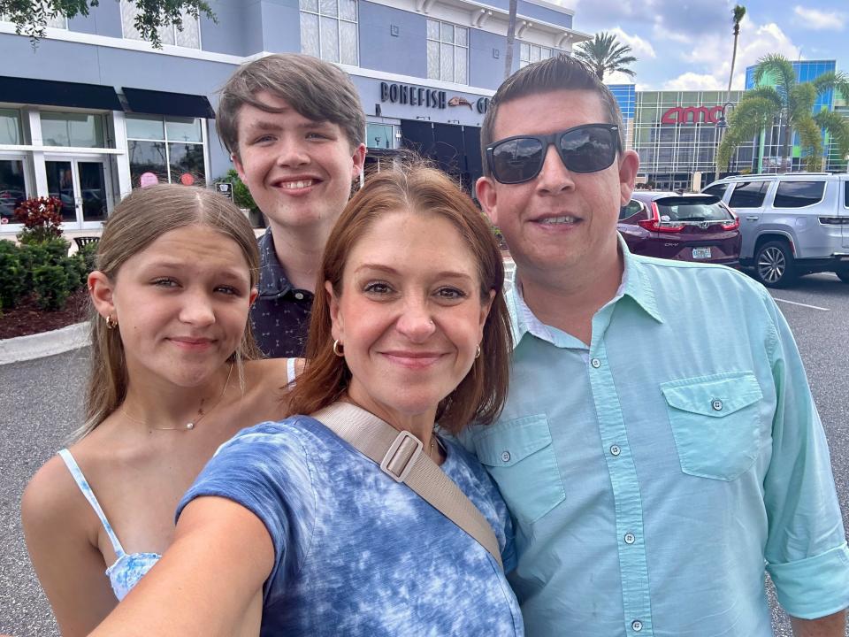 Selfie of the writer, wearing a blue shirt, and her family in front of Bonefish grill. Her husband wears a blue button-down, her son wears a blue shirt, and her daughter wears and blue-and-white tank top