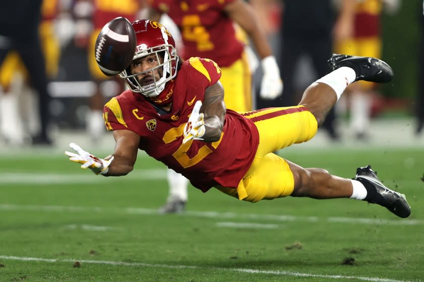 PASADENA, CALIFORNIA - DECEMBER 12: Isaiah Pola-Mao #21 of the USC Trojans intercepts a pass.