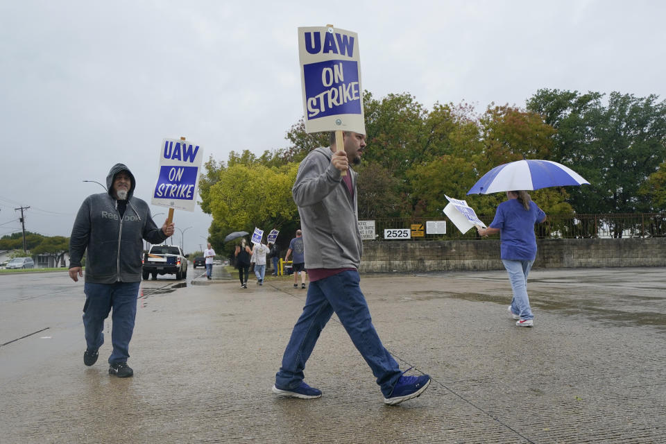 Picketers strike outside of the General Motors assembly plant, Tuesday, Oct. 24, 2023, in Arlington, Texas. The United Auto Workers union is turning up the heat on General Motors as 5,000 workers walked off their jobs at a highly profitable SUV factory in Arlington. (AP Photo/Julio Cortez)