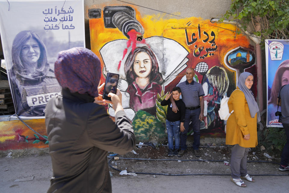 FILE - Palestinians visit the site where veteran Palestinian-American reporter Shireen Abu Akleh was shot and killed, in the West Bank city of Jenin, May 18, 2022. The Al Jazeera news network says it will submit a case file to the International Criminal Court on the killing of reporter Shireen Abu Akleh, who was shot dead earlier this month during an Israeli raid in the occupied West Bank. (AP Photo/Majdi Mohammed, File)