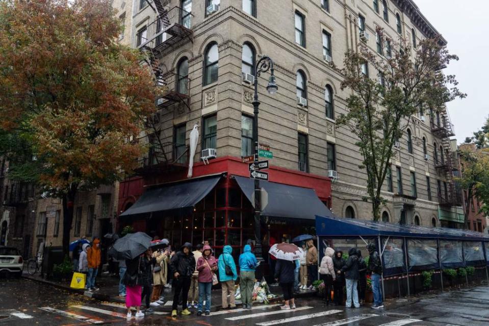 People stand in line to pay tribute to actor Matthew Perry outside the apartment building which was used as the exterior shot in the TV show "Friends" in New York on October 29, 2023. Perry, 54, was known globally for his portrayal of wise-cracking character Chandler Bing on the wildly popular "Friends," which ran for 10 seasons from 1994 to 2004. First responders found Perry unconscious in a hot tub at his house on October 28 and were unable to revive him, law enforcement sources told the Los Angeles Times. Police confirmed they'd mounted a "death investigation for a male in his 50s." (Photo by Adam GRAY / AFP) (Photo by ADAM GRAY/AFP via Getty Images)