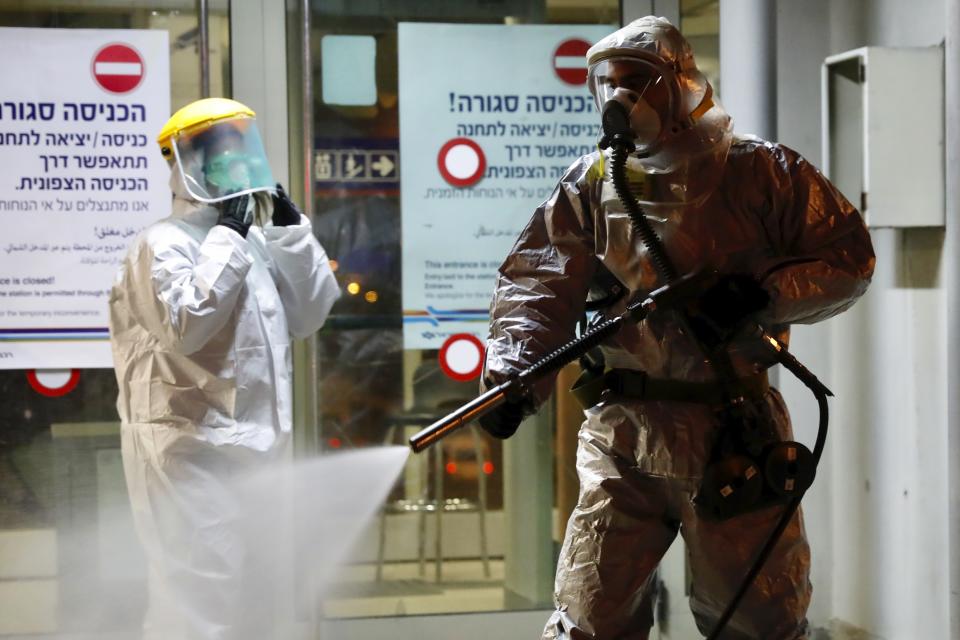 ‏A firefighter sprays disinfectant as a precaution‏ against the coronavirus at the Moshe Dayan Railway Station in Rishon LeTsiyon, Israel, Sunday, March 22, 2020. (AP Photo/Ariel Schalit)