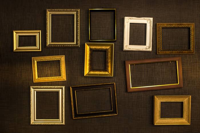 Empty picture frames hang on a wall