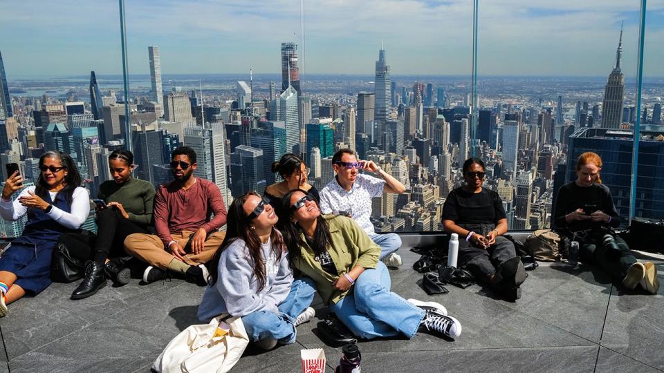 <div>People look toward the sky at the 'Edge at Hudson Yards' observation deck ahead of a total solar eclipse across North America, in New York City on April 8, 2024. (Photo by Charly TRIBALLEAU / AFP)</div>