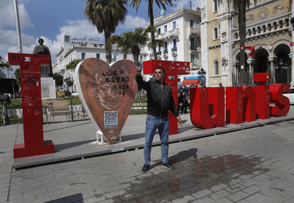 A Tunisian man takes selfie on a street in downtown Tunis, Tunisia, Thursday, March 28, 2019. Tunisia is cleaning up its boulevards and securing its borders for an Arab League summit that this country hopes raises its regional profile and economic prospects. Government ministers from the 22 Arab League states are holding preparatory meetings in Tunis all week for Sunday's summit. (AP Photo/Hussein Malla)
