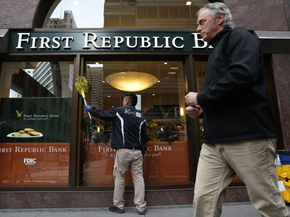 A worker cleans windows at a First Republic Bank office in San Francisco, Calif., earlier this week. U.S. regulators seized the troubled lender on Monday and sold all of its deposits and most of its assets to JPMorgan Chase. (Justin Sullivan/Getty Images - image credit)