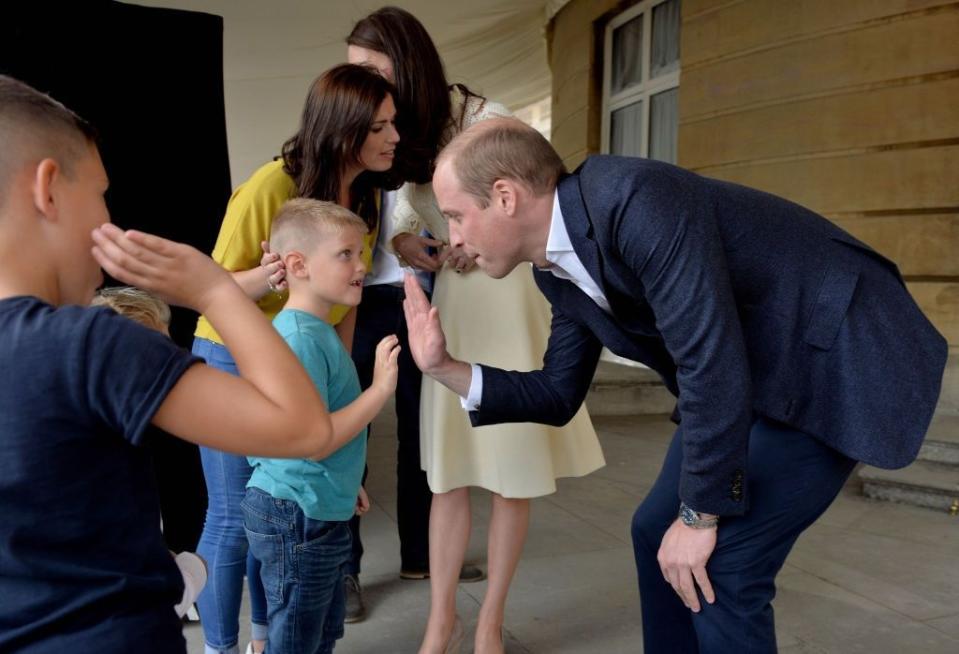 Prince William gives a tea party guest a high five