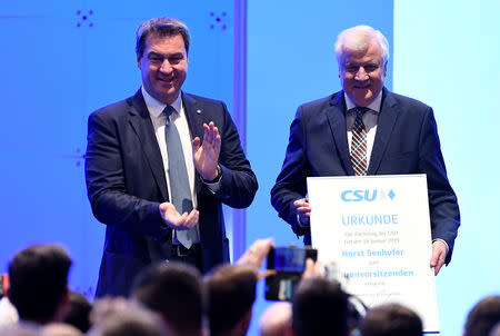 Horst Seehofer, former leader of the Christian Social Union (CSU), receives a certificate for being elected as honorary party chairman, as Bavarian State Prime Minister and new party leader Markus Soeder applauds, during a party meeting in Munich, Germany, January 19, 2019. REUTERS/Andreas Gebert