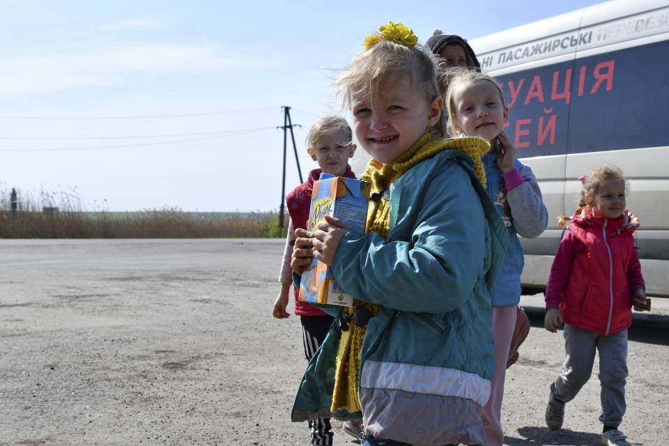 Children wait to board a bus during an evacuation of civilians on a road near Slovyansk, eastern Ukraine, Wednesday, May 4, 2022. (AP Photo/Andriy Andriyenko)