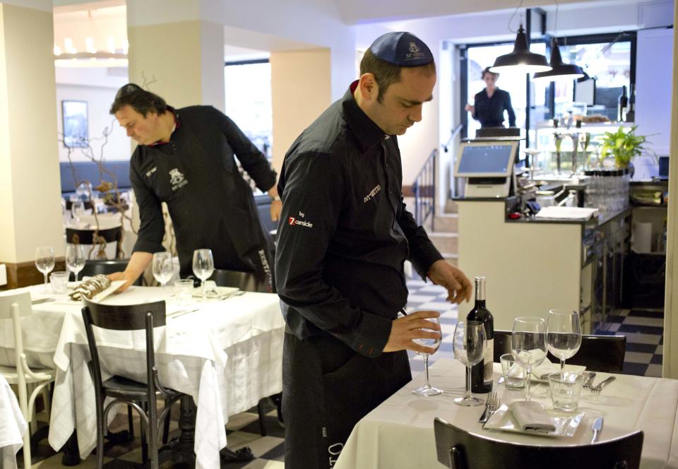 Ba'Ghetto restaurant owners Ilan Dabush, left, and his brother Amit work in their restaurant, during an interview with the Associated Press, in Rome, Monday Jan. 20, 2014. For just one day, the kitchen of the Vatican hotel where Pope Francis lives went kosher, with Rabbi Jaakov Spizzichino overseeing the scrupulous cleaning of countertops, boiling of utensils and heating of the oven necessary to render it fit for cooking under Jewish dietary laws. The occasion? A four-course luncheon Francis hosted last week for a dozen Argentine rabbis. Francis was hosting Rabbi Abraham Skorka and about 15 other rabbis from Buenos Aires who came to Rome en masse to visit their old friend, and the Vatican pulled out all the stops. Organizers turned to Ba'Ghetto, one of the best kosher restaurants in Rome's ghetto on the other side of the Tiber River, to cater the affair. "I decided to do it simple, because the pope is simple," said Amit Dabush, Ba'Ghetto's Israeli-born co-owner. "But the menu was full: He had to make a 'bella figura,'" or a good impression on his guests. (AP Photo/Alessandra Tarantino)