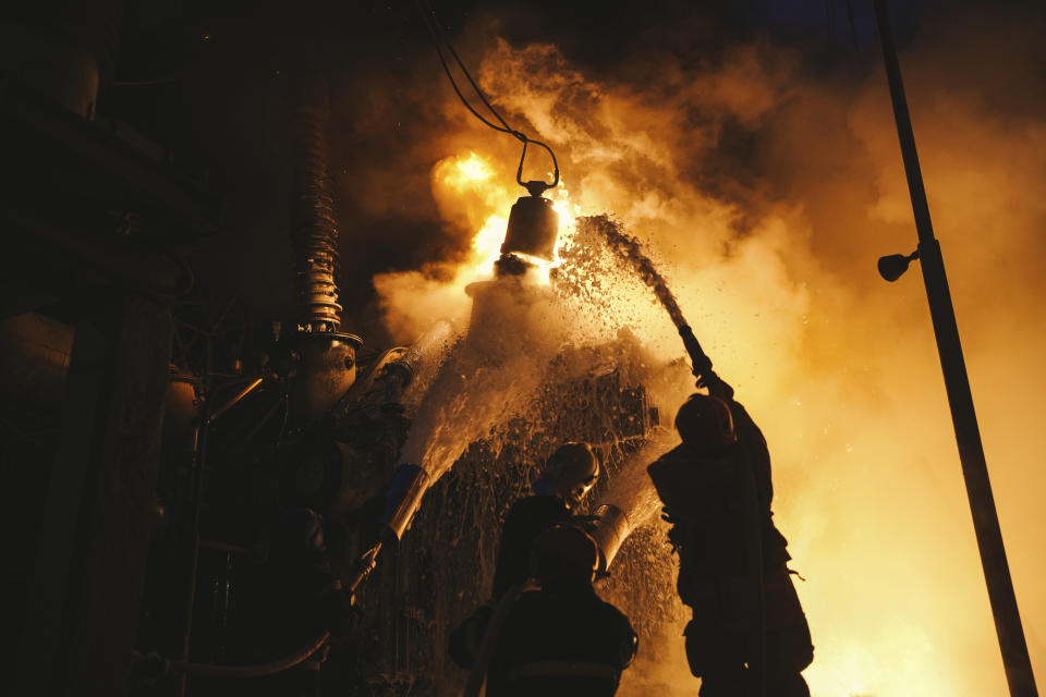 In this photo released by State Emergency Service of Ukraine on Monday, Dec. 19, 2022, Ukrainian State Emergency Service firefighters work to extinguish a fire at an infrastructure facility after a Russian drone attack in Kyiv, Ukraine. (Pavel Petrov, SESU via AP)