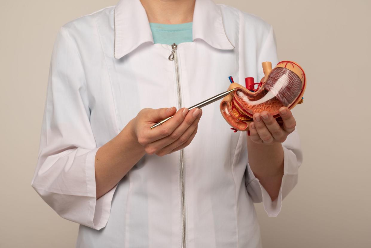 woman doctor pointing at stomach mockup