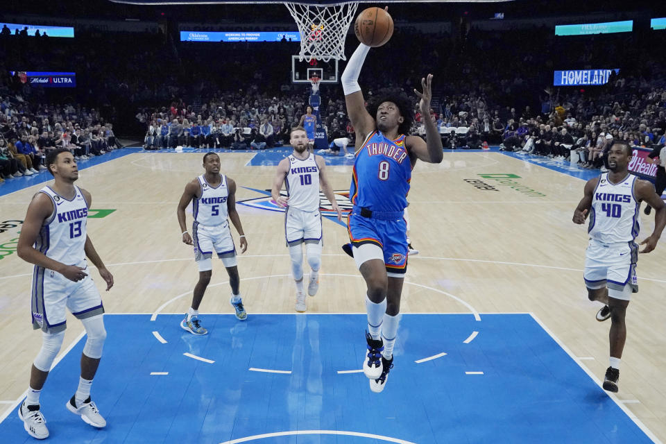 Oklahoma City Thunder forward Jalen Williams (8) goes to the basket between Sacramento Kings forward Keegan Murray (13), guard De'Aaron Fox (5), forward Domantas Sabonis (10) and forward Harrison Barnes (40) in the first half of an NBA basketball game Sunday, Feb. 26, 2023, in Oklahoma City. (AP Photo/Sue Ogrocki)