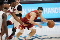 Denver Nuggets guard Facundo Campazzo, right, drives past Miami Heat forward Precious Achiuwa during the first half of an NBA basketball game Wednesday, April 14, 2021, in Denver. (AP Photo/David Zalubowski)