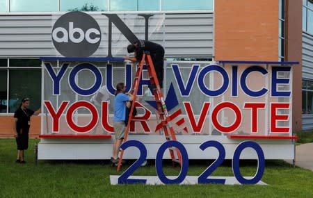 Works crews set up sign next to the debate hall as preparations continue for the Democratic Presidential Debate in Houston, Texas