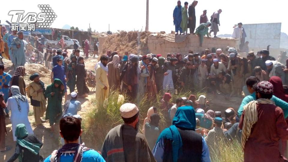 塔利班份子及阿富汗人民圍觀在駁火中喪命的政府軍士兵。（圖／達志影像美聯社）