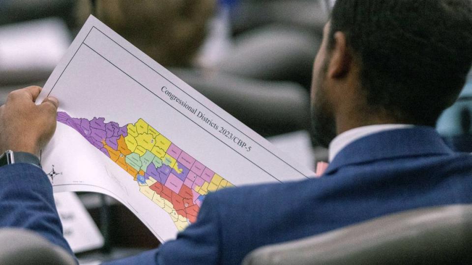 A North Carolina Senate staffer looks over a proposed congressional map during a Senate Committee on Redistricting and Elections meeting at the Legislative Office Building in Raleigh, Thursday, October. 19, 2023.