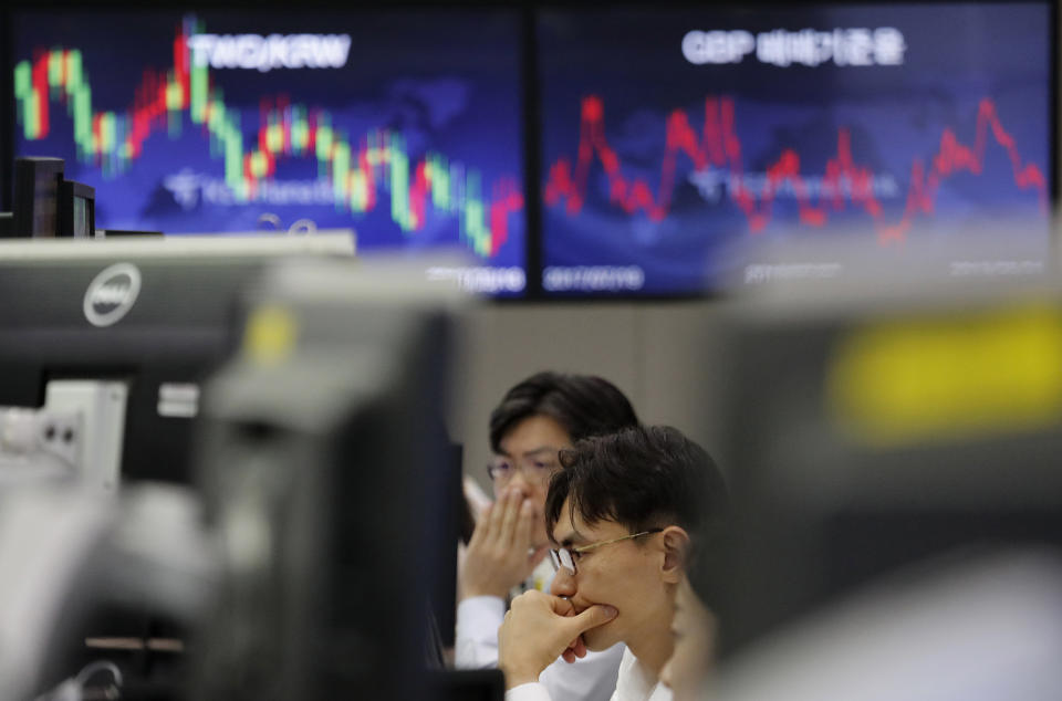 In this Aug. 1, 2019, photo, currency traders watch monitors at the foreign exchange dealing room of the KEB Hana Bank headquarters in Seoul, South Korea. Asian shares were mostly higher Wednesday, Aug. 14, 2019, after the U.S. said it would hold off on tariffs of Chinese imports of mobile phones, toys and several other items typically on holiday shopping lists. (AP Photo/Ahn Young-joon)