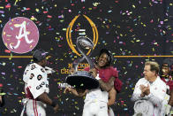 Alabama's Jameson Williams (1) holds up the winner's trophy as coach Nick Saban, right, and Brian Robinson Jr., left, watch after the Cotton Bowl NCAA College Football Playoff semifinal game against Cincinnati, Friday, Dec. 31, 2021, in Arlington, Texas. Alabama won 27-6. (AP Photo/Jeffrey McWhorter)