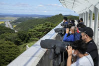 Visitors watch the North Korea side from the Unification Observation Post in Paju, South Korea, near the border with North Korea, Sunday, Sept. 26, 2021. The powerful sister of North Korean leader Kim Jong Un said Saturday that her country will take steps to repair ties with South Korea, and may even discuss another summit between their leaders, if the South drops what she described as hostility and double standards. (AP Photo/Ahn Young-joon)