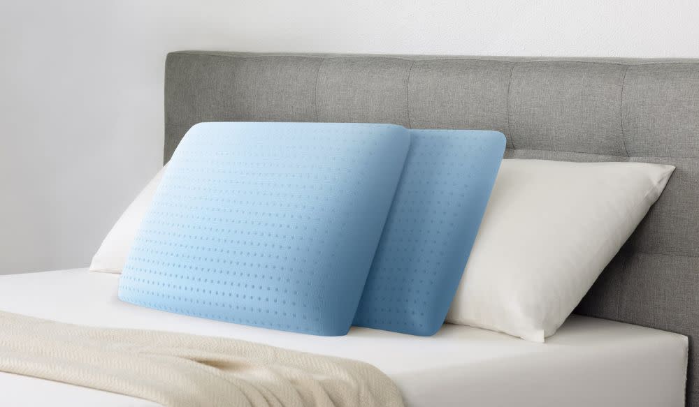 Four pillows — two blue, two white — on a bed
