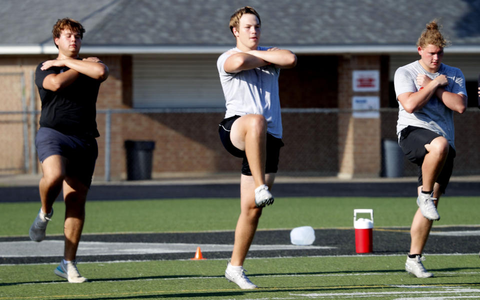 With social distancing in mind, student athletes run a drill during the re-opening of a strength and conditioning camp at Arlington Martin High School Thursday, June 18, 2020, in in Arlington, Texas. While states have been easing the economic and social lockdowns prompted by the coronavirus pandemic, some are now letting high school athletes return for summer workouts before teachers have even figured out how they are going to hold classroom instruction. (AP Photo/LM Otero)