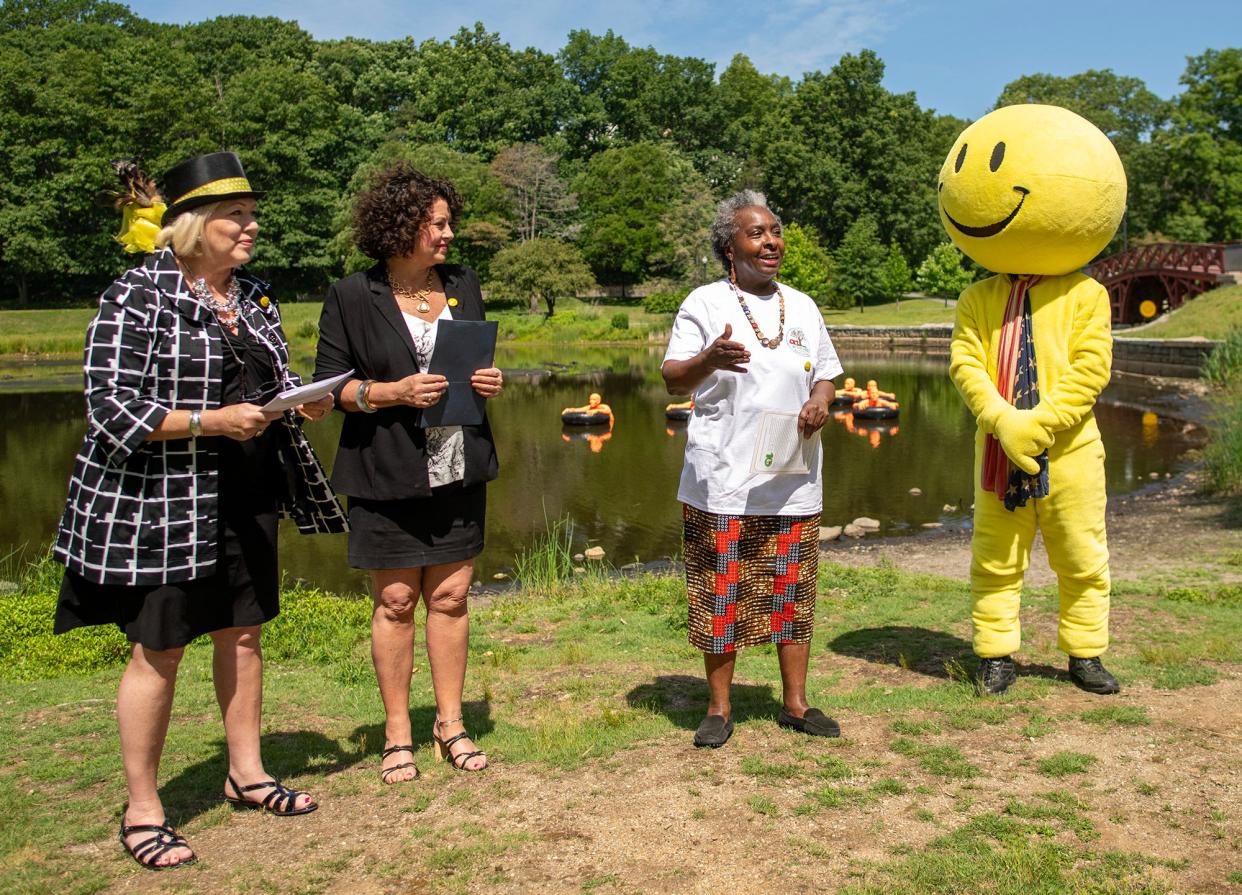 From left, Harvey Ball founding chair Barbara Guertin and co-chair Ursula Arello, announce the 2023 Harvey Ball Smile Award, 'The Harvey,' will go to Gloria Hall and the Art in the Park Committee. The announcement was made with Smiley in Elm Park June 22