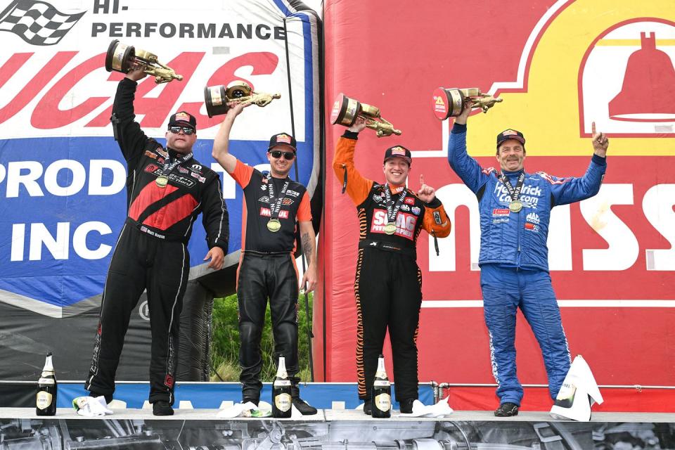 a group of men holding trophies