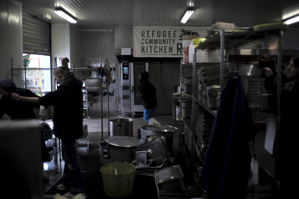 Volunteers from the "Refugee Community Kitchen" association prepare food in Calais, northern France, Saturday, Nov. 27, 2021. At the makeshift camps outside Calais, migrants are digging in, waiting for the chance to make a dash across the English Channel despite the news that at least 27 people died this week when their boat sank a few miles from the French coast. (AP Photo/Rafael Yaghobzadeh)