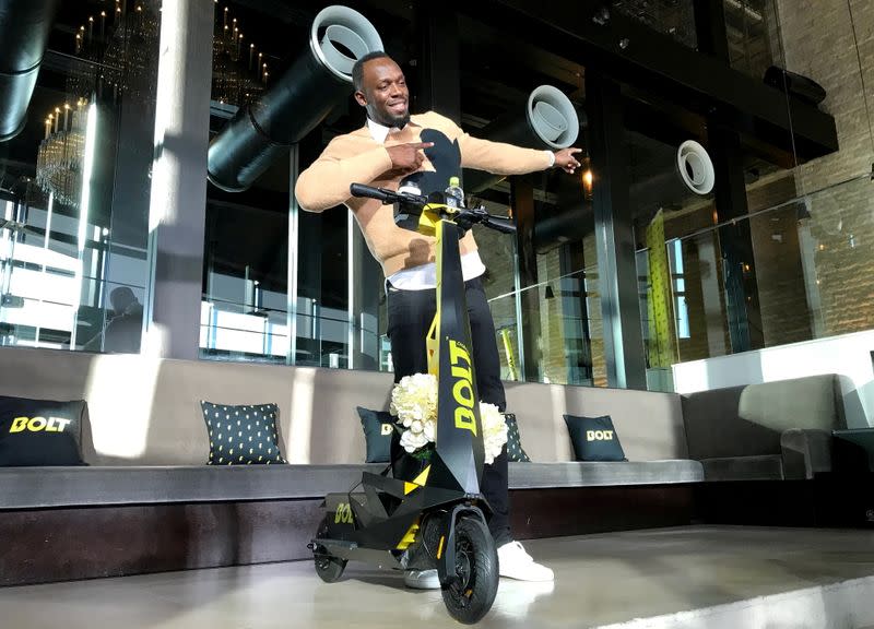 FILE PHOTO: Olympic gold medallist Usain Bolt poses for a photograph as he shows off an electric scooter at a launch event in Tokyo