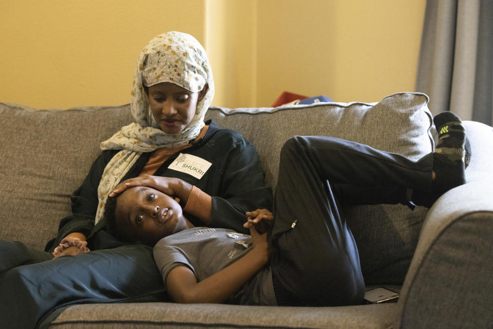 Shukri Olow, left, a Muslim woman who is running for King County Council District 5, watches television with her son, Khalid Ahmed, 9, Friday, Aug. 13, 2021, at their home in Kent, Wash., south of Seattle. Muslim Americans in their 20s and 30s who grew up amid the aftershocks of the Sept. 11, 2001 terrorist attacks came of age in a world not necessarily attuned to their interests, their happiness and their well-being. Olow says the aftermath of the attacks has helped motivate her to become a community organizer and to run for office in Washington state. (AP Photo/Karen Ducey)