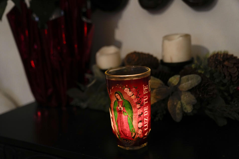 A candle burns in the Sanchez home Tuesday, Dec. 26, 2023, in Chicago. When she was 1, Noelia Sanchez and her mother Aurora, who had no work documents, were rounded up with dozens of other immigrants in a Texas town near the border. The U.S.-born child and her mother were forced to go to Mexico along with hundreds of thousands of other people. (AP Photo/Erin Hooley)