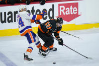 Philadelphia Flyers' Jakub Voracek (93) and New York Islanders' Travis Zajac (14) battle for the puck during the third period of an NHL hockey game, Sunday, April 18, 2021, in Philadelphia. (AP Photo/Matt Slocum)